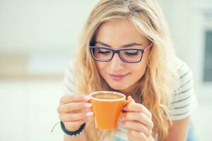 taza de café en mano de contento joven mujer. foto