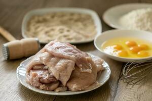 Ingredients for wiener schnitzels, chicken meat, eggs, breadcrumbs and flour photo