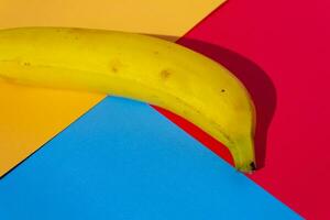 Banana in vibrant colors background, with squares and rectangular shapes in the background. photo