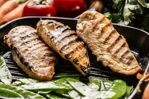 Grilled chicken breast in grill pan with sweet peas and seasoning vegetable photo