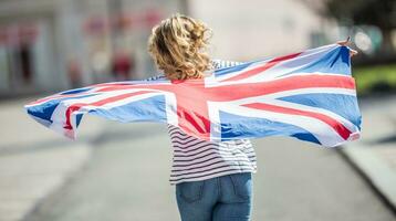 atractivo contento joven niña con el bandera de el genial Bretaña foto