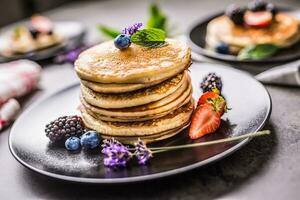 Pancakes with strawberries blackberries blueberries and levander. photo