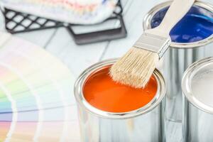 Paint cans brush and color palette on table. photo