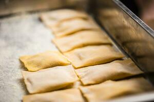 Uncooked hand-made Italian pasta ravioli ready for cooking photo