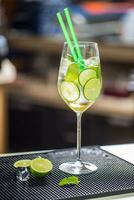 Cocktail drink or lemonade with cucumber on barcounter photo