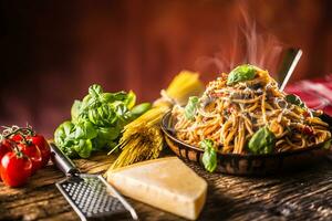 Italian pasta spaghetti with tomato sauce olive oil basil and parmesan cheese in old pan photo