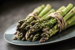Close-up Bunch of fresh asparagus on plate photo
