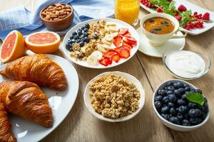 Healthy breakfast served with plate of yogurt muesli blueberries strawberries and banana. photo