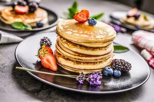 Pancakes with strawberries blackberries blueberries and levander. photo