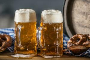 Oktoberfest dos grande cerveza con galleta salada de madera barril y azul Manteles foto