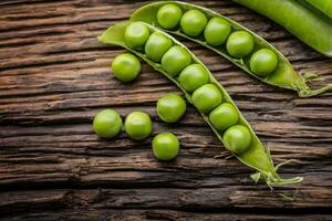 Peas. Fresh bio homemade peas and pods on old oak board. Healthy fresh green vegetable - peas and pods. photo