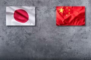 China and Japan flags. China and Japan flag on concrete background photo