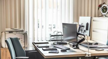 Empty office equipped with computers, tablets, printer and office furniture photo