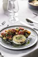 Goat cheese with baked beetroot salad styled on a plate in a restaurant photo