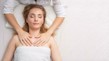 Female therapist healing a lying young girl by touch of her hands on a white background photo