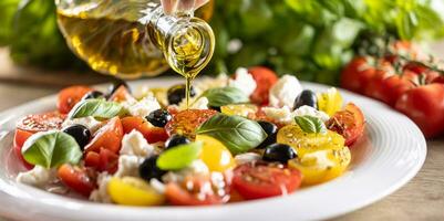 Olive oil is pouring from carafe on Caprese salad photo