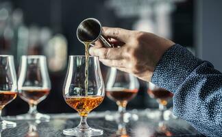 Bartender hand pouring alcoholic drink in nightclub, bar or pub. photo