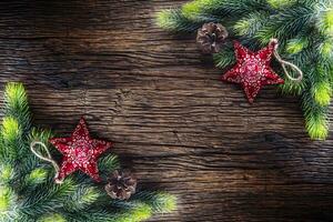 Navidad. Navidad abeto árbol con estrella y pino cono en rústico de madera mesa. diagonalmente composición frontera foto