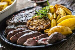 Grilled beef Rib Eye steak with garlic american potatoes rosemary salt and spices photo