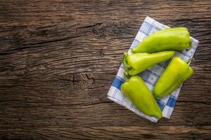 Green peper.Fresh green pepper blue checkered tablecloth on old oak table. photo