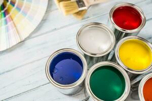 Paint cans brushes and color palette on table photo