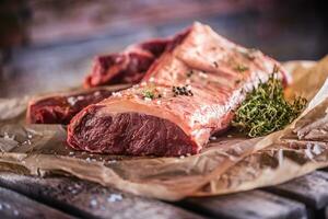 Raw rib eye beef steak with salt spices and herbs photo