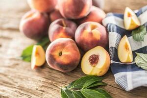 A group a ripe peaches on wooden table photo