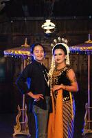 a Javanese dancer taking pictures with fans on stage photo