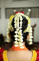 a traditional Javanese dancer wears very beautiful jasmine flowers in her black hair photo