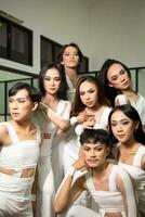 a group of Asian dancers get together and make silly faces while taking pictures on the dance floor photo