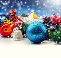 Christmas concept consisting of blue ball, lovely apples, small tree branches, stars and bokeh background. photo