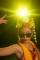 a Javanese dancer dances very skillfully while wearing sunglasses on her eyes and very beautiful facial makeup photo