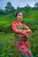 an Asian woman standing and posing among the tea leaves photo