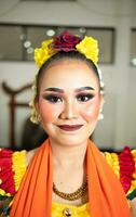 beautiful face of a traditional Indonesian dancer wearing flowers and charming makeup before performing photo