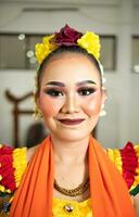 beautiful face of a traditional Indonesian dancer wearing flowers and charming makeup before performing photo