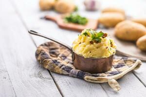 Mashed potatoes in pan decorated with parsley herbs. photo