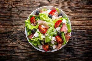 Salad. Fresh summer lettuce salad.Healthy mediterranean salad olives tomatoes parmesan cheese and prosciutto. photo