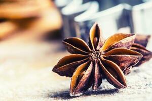 Star anise cookie cutter cinnamon and flour on baking board. Christmas baking utensil and holiday concept photo