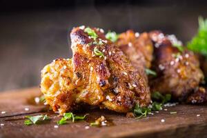 Chicken wings grilled BBQ  parsley herb and sesame on wooden board. photo