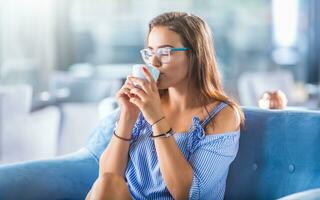 Beautiful young woman with a cup of coffee or tea in the cafe photo