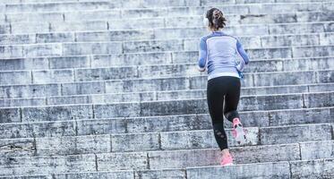 joven mujer haciendo Deportes y corriendo arriba el escalera foto