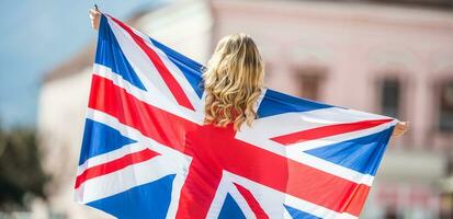 Attractive happy young girl with the flag of the Great Britain photo