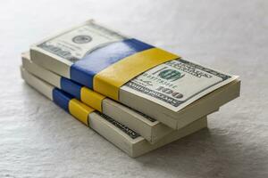 Bundles of dollar bills tied with the Ukrainian flag. The concept of support of the American government, for the war-torn photo