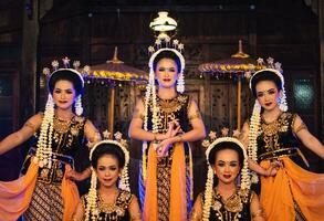 a group of Javanese dancers poses dancing with their friends while taking pictures on the stage photo