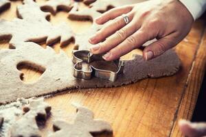 Gingerbread dough and woman hands preparing christmas biscuit cakes photo