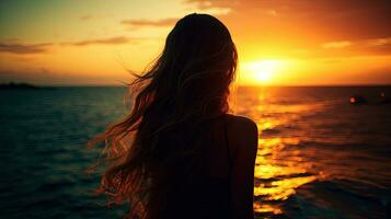 Girl s silhouette against sea and sunset photo