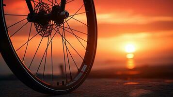 Sunset background with bicycle wheel. silhouette concept photo