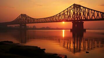 amanecer silueta de hola puente un suspendido lapso terminado el holgazán río en Oeste Bengala foto