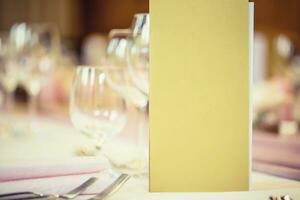 Served table with menu brochure in restaurant, closeup. Free space for your text or information photo