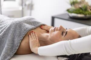 Woman lies with closed eyes as masseuse rubs her shoulders to ease work-related accumulated tension photo